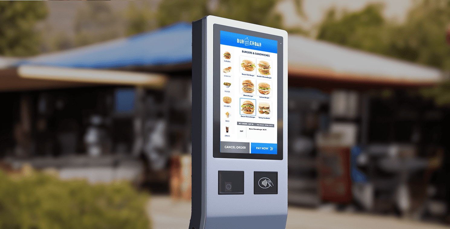 Outdoor touchscreen kiosk displaying a digital menu for a burger restaurant, showcasing AI-driven drive-through ordering technology in a QSR environment.