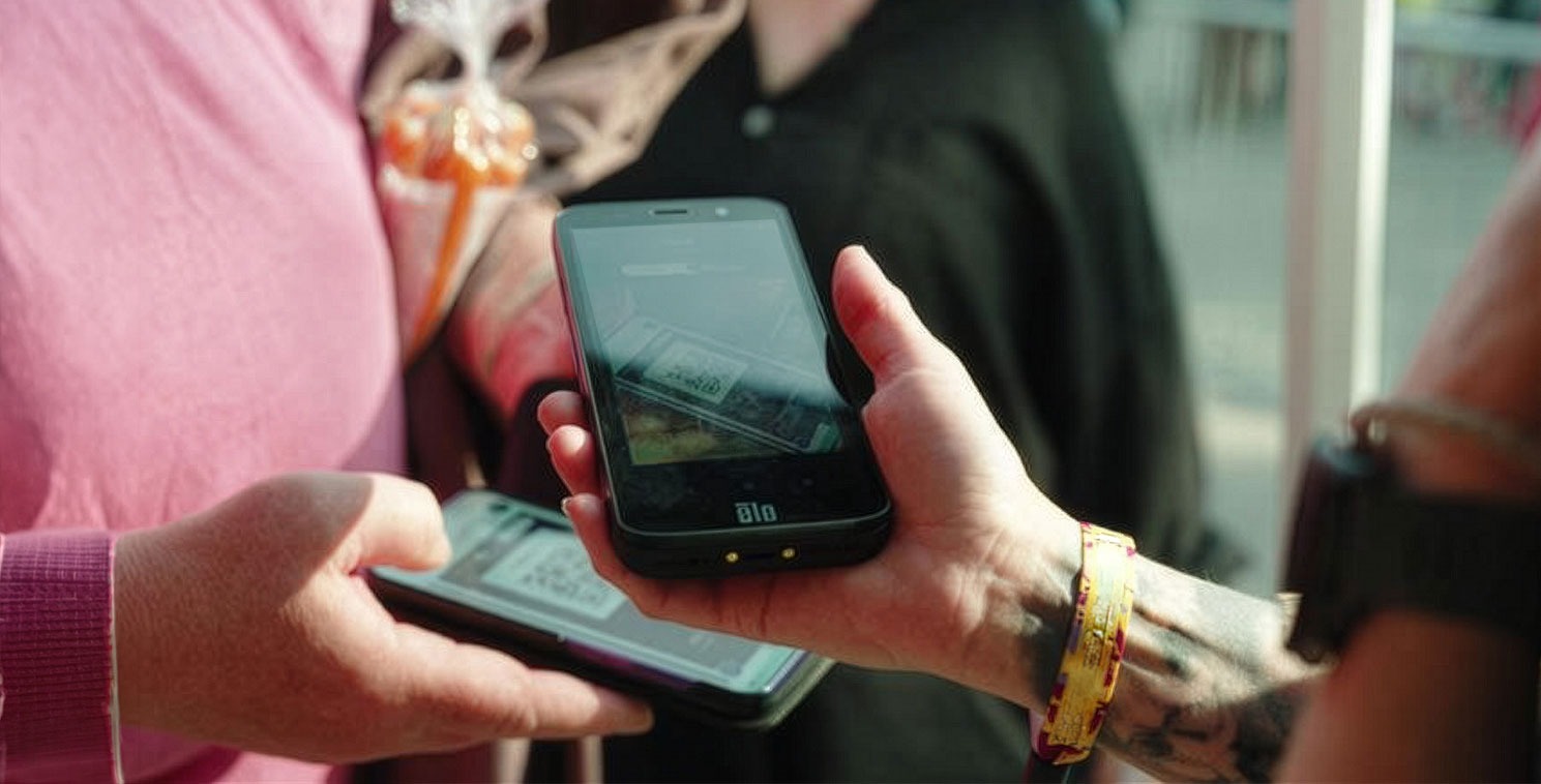 A festival staff member using an Elo M51 mobile computer to scan a digital ticket QR code at a high-volume event entrance.